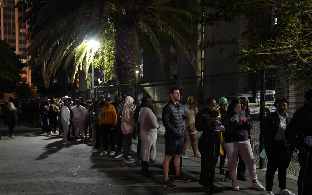People queue after dark to cast their votes at a polling station in Cape Town, South Africa, Wednesday, May 29, 2024. South Africans voted Wednesday at schools, community centers, and in large white tents set up in open fields in an election seen as their country’s most important since apartheid ended 30 years ago. It could put the young democracy into unknown territory. (AP Photo/Nardus Engelbrecht)