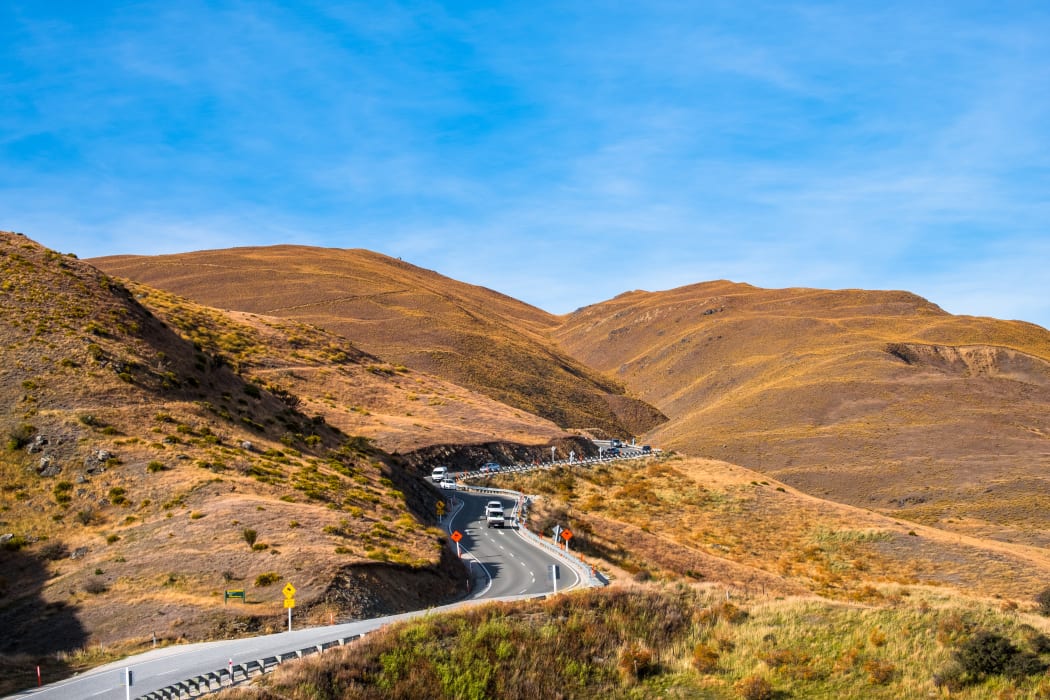 The beautiful Crown Range Road between Queenstown and Wanaka via Crown range. Grassland and beautiful landscape of rocky mountains.