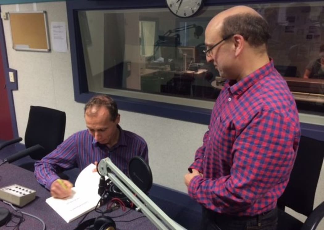David Farrar has his copy of "Dirty Politics" signed by author Nicky Hager in Radio New Zealand's Morning Report studio.