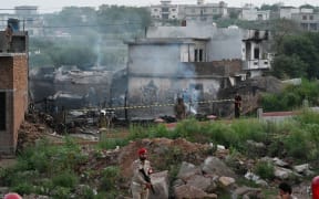 Military personnel work at the scene where a Pakistani Army Aviation Corps aircraft crashed in Rawalpindi on July 30, 2019. - Fifteen people were killed when a small plane crashed into a residential area in the Pakistani city of Rawalpindi near the capital Islamabad. (Photo by AAMIR QURESHI / AFP)