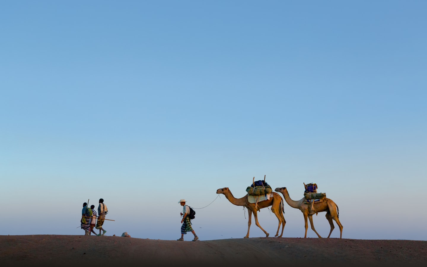 Afar, Ethiopia - 2013: National Geographic Explorer and writer Paul Salopek (center) follows local guides into the Afar Desert on a 22,000-mile walk to retrace the human diaspora.