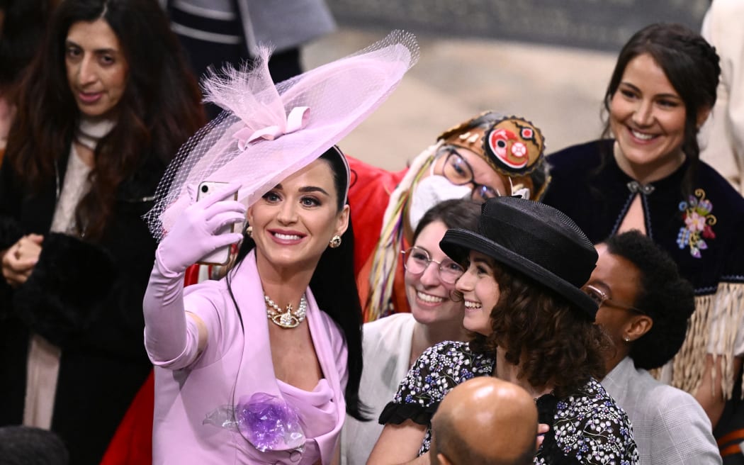 American singer-songwriter Katy Perry takes selfie photos with guests at Westminster Abbey in central London on May 6, 2023, during the coronations of Britain's King Charles III and Britain's Camilla, Queen Consort. - The set-piece coronation is the first in Britain in 70 years, and only the second in history to be televised. Charles will be the 40th reigning monarch to be crowned at the central London church since King William I in 1066. Outside the UK, he is also king of 14 other Commonwealth countries, including Australia, Canada and New Zealand. Camilla, his second wife, will be crowned queen alongside him, and be known as Queen Camilla after the ceremony. (Photo by Gareth Cattermole / POOL / AFP)