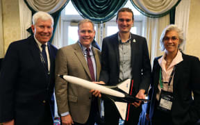Dr. George Nield (Chairman, Global Spaceport Alliance), Jim Bridenstine (Managing Partner of the Artemis Group and Former NASA Administrator), Stefan Powell (CEO, Dawn Aerospace), and Khaki Rodway (Spaceplane Sales & Operations Director, USA, Dawn Aerospace) with a sub-scale Aurora spaceplane at the Oklahoma Breakfast during Space Symposium 2025 in Colorado Springs.