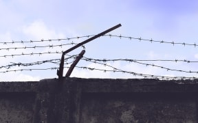 Barbed wire running along top of high wall