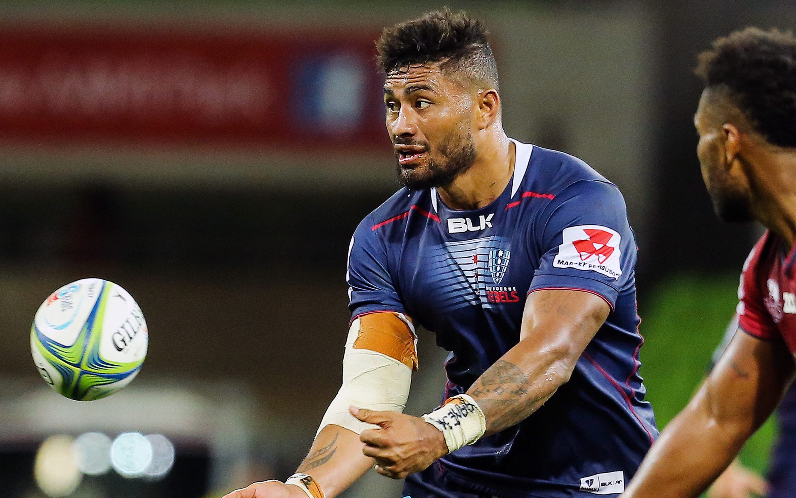 Amanaki Mafi (left) of Melbourne Rebels passes the ball during the Melbourne Rebels vs Queensland Reds in the Vodafone Super Rugby at AMMI Park, Melbourne, Australia on 23 February 2018.