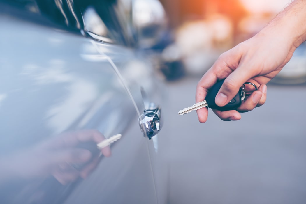 Men's hand using key unlock doors car