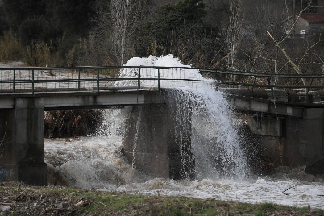 Water from a broken pipe on a damaged bridge flows into the Ter flooded river in Angles, near Girona.