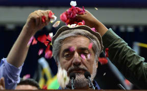 Afghan presidential candidate Abdullah Abdullah is showered with rose petals by supporters at a rally in Kabul.