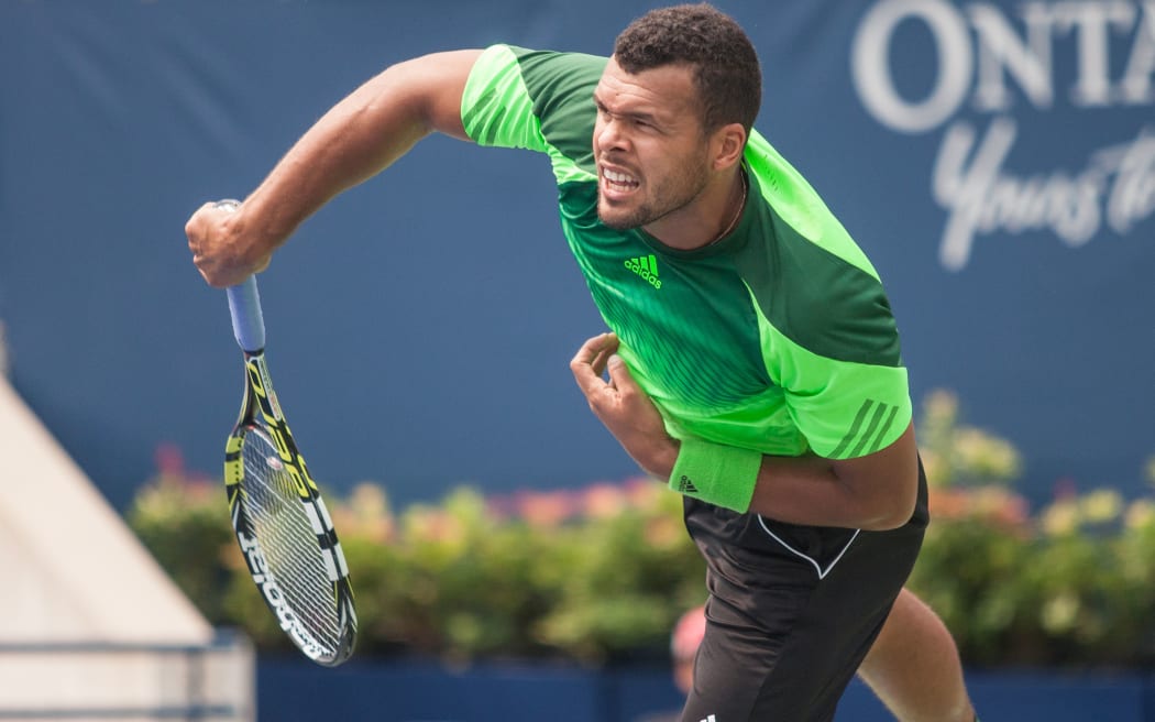 Jo-Wilfried Tsonga (FRA) returns the ball during his match against Novak Djokovic (SRB) at the 2014 Rogers Cup being played in Toronto.