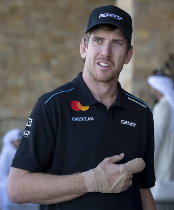 Peter Burling, co-CEO and driver of Black Foils SailGP Team looks on after sustaining a finger injury, Abu Dhabi, 2025.