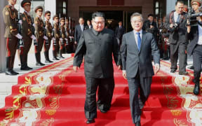 South Korea's President Moon Jae-in (R) and North Korea's leader Kim Jong Un (L) walking together after the summit at the north side of the truce village of Panmunjom in the Demilitarized Zone dividing the two Koreas.