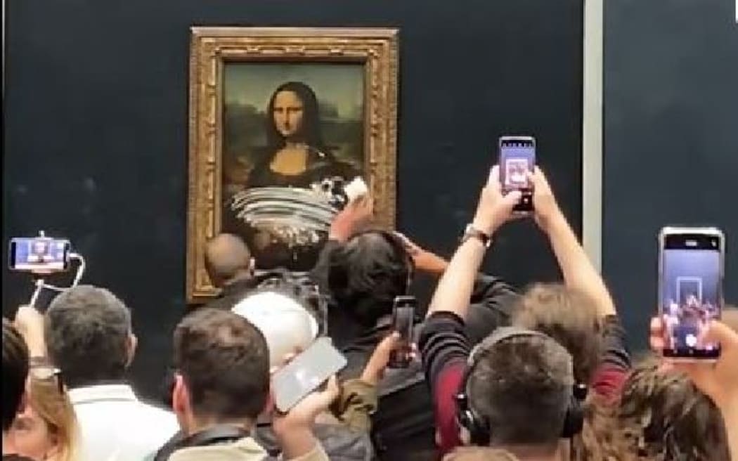 Mona Lisa Man dressed as old woman throws cake at da Vinci painting