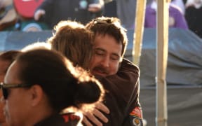 Two people embrace in a hug.