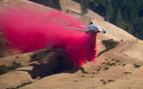 A plane drops fire retardant while battling the Soberanes Fire in Carmel Highlands, California on 23 July 2016.