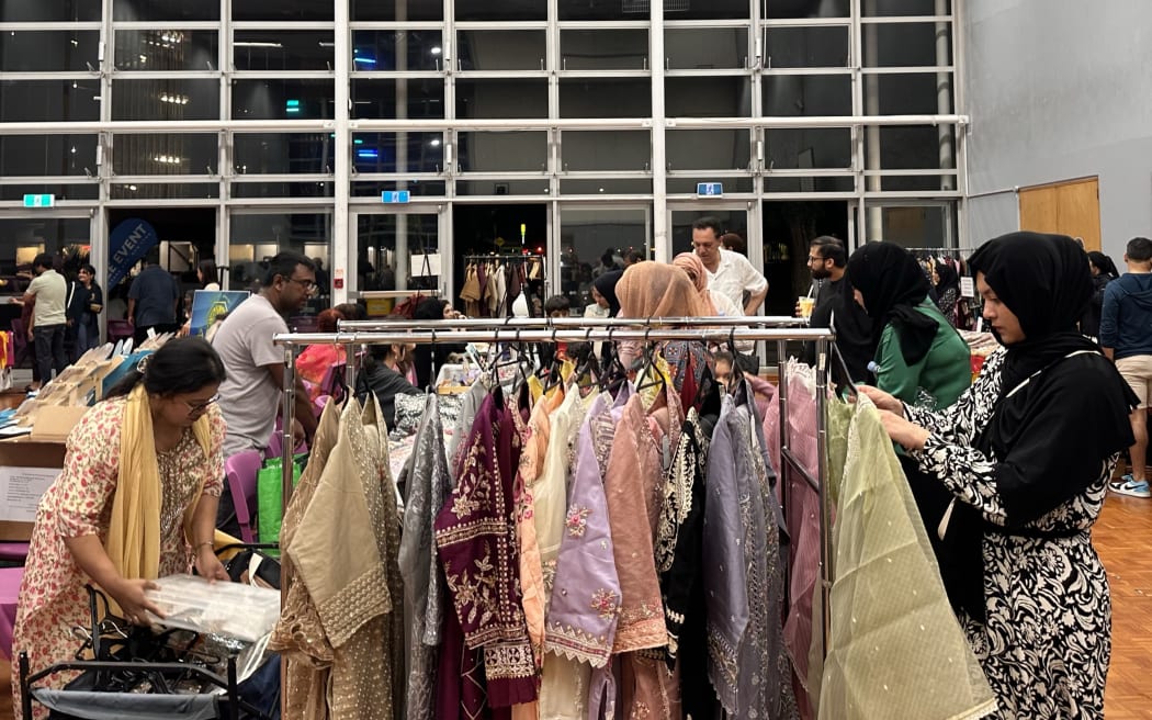 Vendors and patrons at a Ramadan Night Market clothing stall.