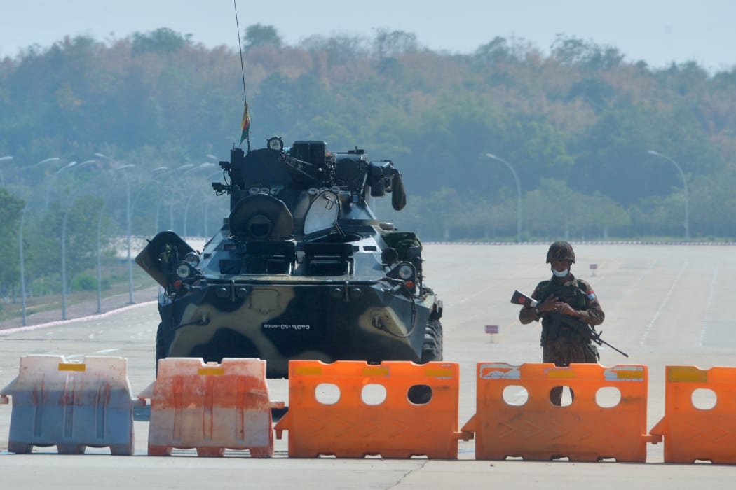 A soldier stands guard on a blockaded road to Myanmar's parliament in Naypyidaw on 1 February 2021, after the military seized power in a coup against the elected government of NLD leader Aung San Suu Kyi.