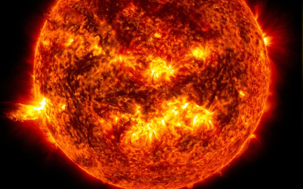 An image of the sun, showing a glowing fiery ball of orange and yellow suspended in the black nothingness of space.