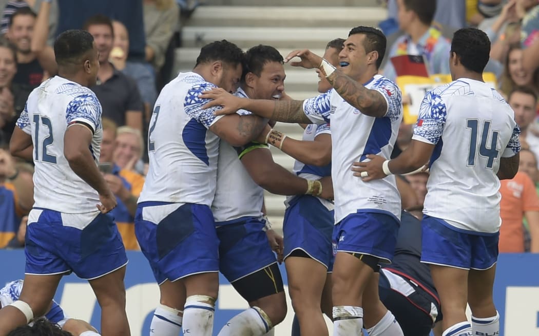 Manu Samoa captain Ofisa Treviranus celebrates with teammates after scoring a try.