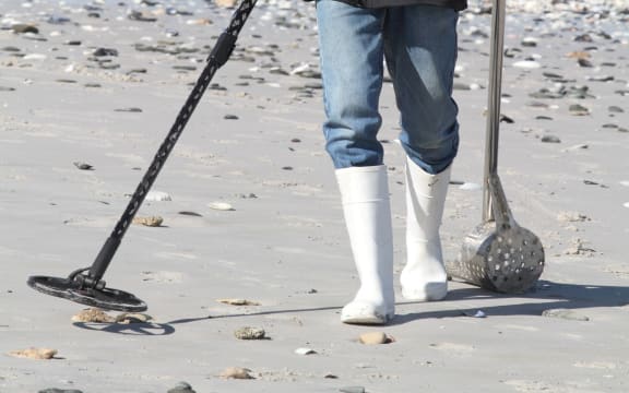 Man with metal detector on beach