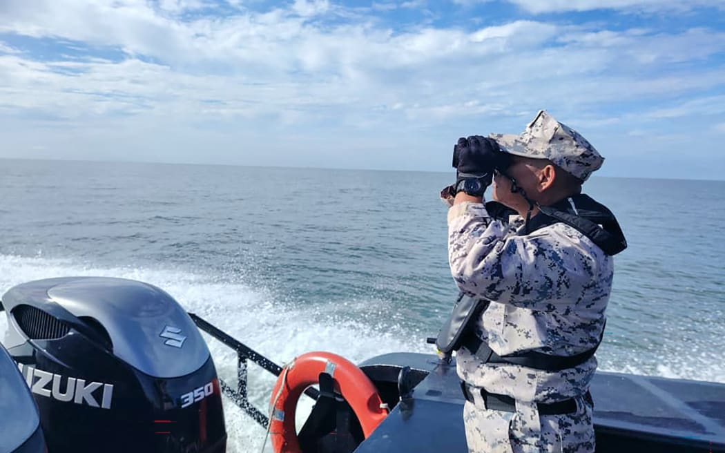 This handout picture taken and released by the Malaysian Maritime Enforcement Agency (MMEA) on November 9, 2025 shows a MMEA staff member searching for suvivors after a boat carrying migrants from Myanmar capsized near the Malaysia–Thailand border, during a search and rescue operation off the coast of Langkawi. Malaysia was searching for survivors after a boat carrying migrants capsized near the Thai border, killing at least one and leaving many others missing, a maritime agency official said on November 9, 2025. (Photo by Handout / MALAYSIAN MARITIME ENFORCEMENT AGENCY / AFP) / RESTRICTED TO EDITORIAL USE - MANDATORY CREDIT "AFP PHOTO /  MALAYSIAN MARITIME ENFORCEMENT AGENCY" - HANDOUT - NO MARKETING NO ADVERTISING CAMPAIGNS - DISTRIBUTED AS A SERVICE TO CLIENTS