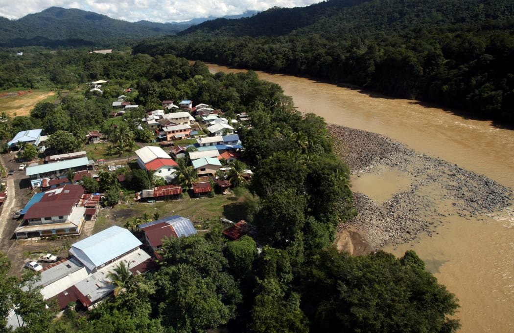 A Kenyah tribal settlement (left) lies next to a murky and silted Baram river, Miri interior, eastern Malaysian Borneo state of Sarawak, on 12 December 2007.