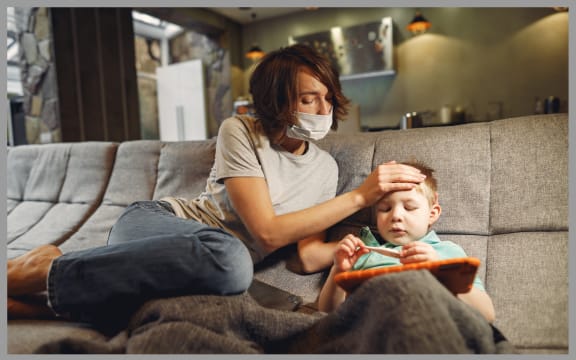 Sick child at home with mum in a mask