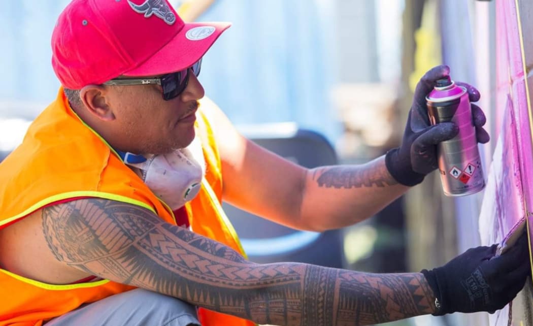 Pascal Atiga-Bridger completing a mural in South Auckland.