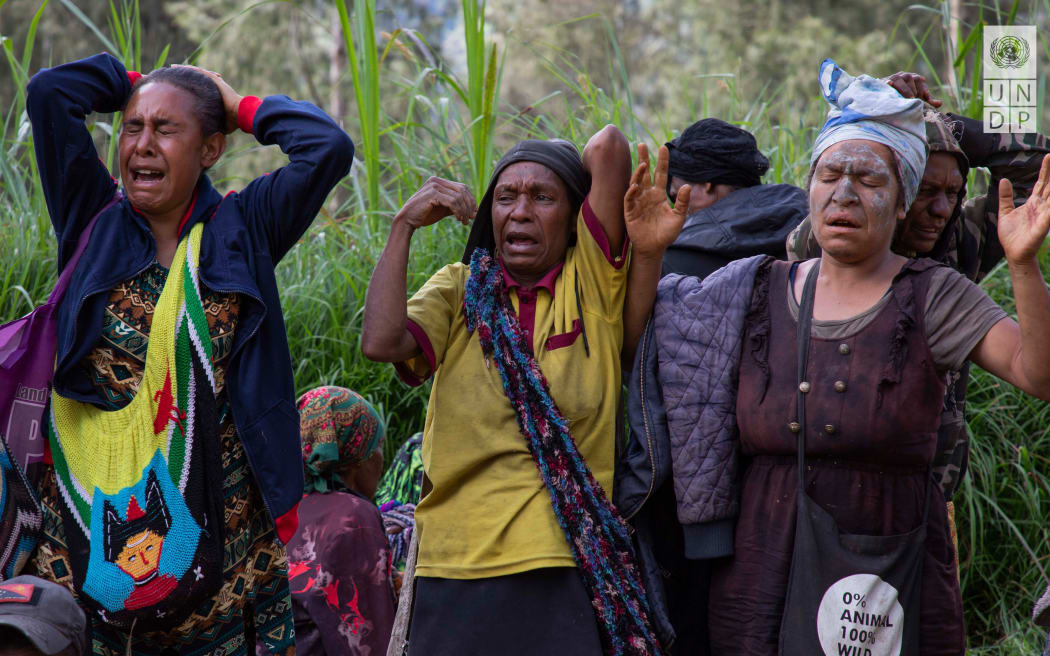 Women grieving at Yambali village where about 2000 people are buried.