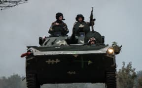 Ukrainian soldiers drive an armoured personnel carrier (APC) in Kupiansk, in the recently retaken area near Kharkiv on September 30, 2022.