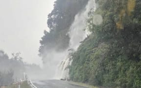Water cascades from Ormans Falls onto the Haast Pass, south of Haast township. Credit: The Coasters Club