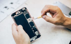 Technician repairs and inserts the sim memory card on the mobile phone in electronic smartphone technology service. Cellphone technology device maintenance engineer