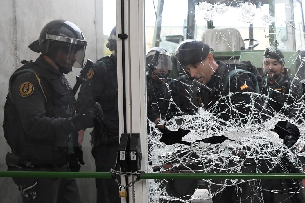 Spanish Guardia Civil guards brake the door of a polling station in Sant Julia de Ramis.
