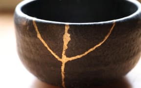 A picture shows a bowl mended with Kintsugi, Japanese traditional repair method of ceramics, in Tokyo on May 18, 2021. Broken potteries are glued with lacquer and finished with gold and other metal powders. There are some national treasures that were mended with Kintsugi, as the Kintsugi raises artistic quality. ( The Yomiuri Shimbun ) (Photo by Kentaro Aoyama / The Yomiuri Shimbun via AFP)