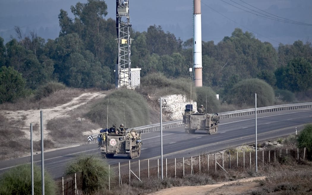 Israeli soldiers ride armoured vehicles along a road on the outskirts of the southern Israeli city of Sderot, near the border with Gaza, on 28 October.