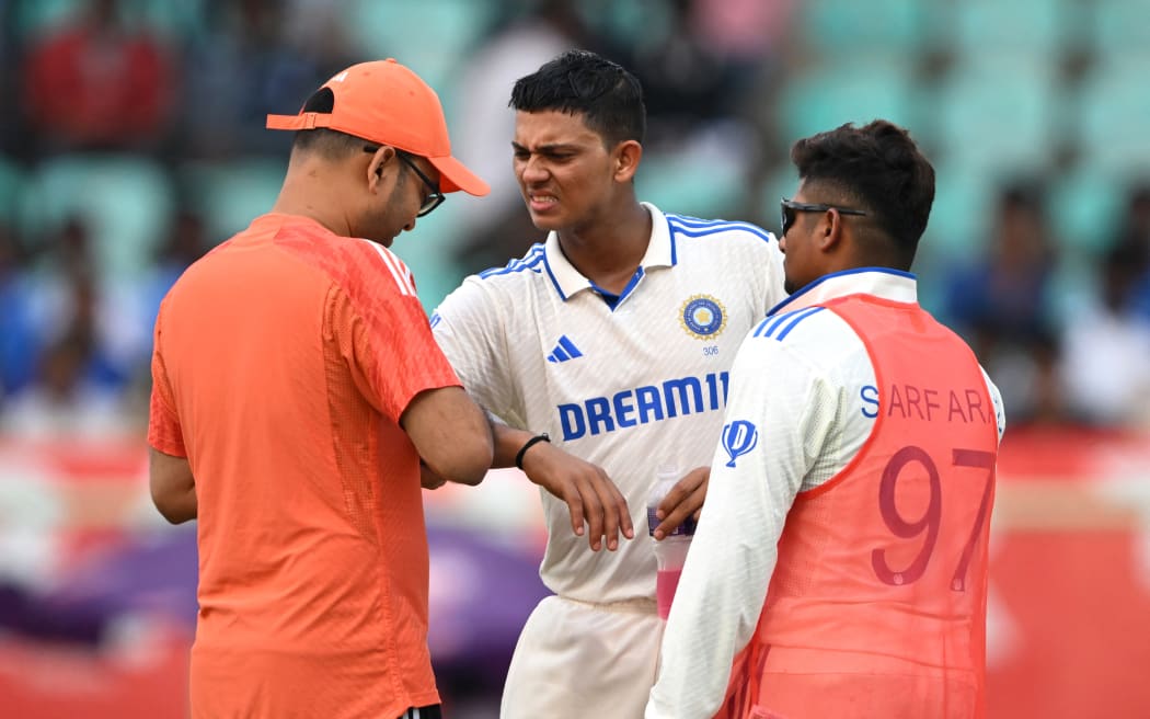 India's Yashasvi Jaiswal (C) receives medical assistance during the first day of the second Test cricket match between India and England at the Y.S. Rajasekhara Reddy cricket stadium in Visakhapatnam on February 2, 2024. (Photo by Dibyangshu SARKAR / AFP) / -- IMAGE RESTRICTED TO EDITORIAL USE - STRICTLY NO COMMERCIAL USE --