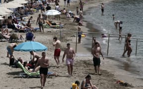 People enjoy the beach at south suburbs of Athens, during the first day of the official reopening of beaches to the public on 16 May 2020.