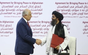 US Special Representative for Afghanistan Reconciliation Zalmay Khalilzad (left) and Taliban co-founder Mullah Abdul Ghani Baradar shake hands after signing the peace agreement between US, Taliban, in Doha, Qatar on 29 February, 2020.