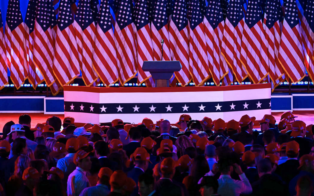 Supporters wait for former US President and Republican presidential candidate Donald Trump to arrive at an election night event at the West Palm Beach Convention Center in West Palm Beach, Florida, on November 6, 2024. (Photo by Jim WATSON / AFP)