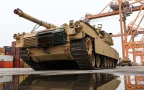 In this file photo taken on 3 December, 2022, an M1A2 Abrams battle tank of the US army, that will be used for military exercises by the 2nd Armored Brigade Combat Team, is unloaded at the Baltic Container Terminal in Gdynia, Poland.