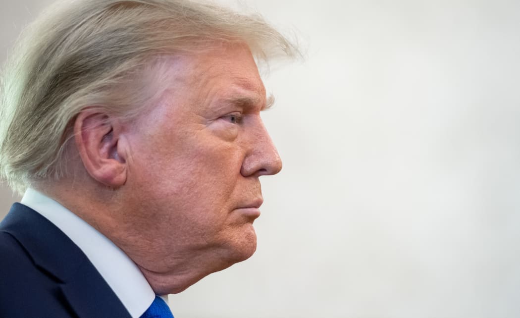 In this file photo US President Donald Trump looks on during a ceremony presenting the Presidential Medal of Freedom to wrestler Dan Gable in the Oval Office of the White House in Washington, DC on 7 December 2020. -