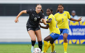 New Zealand's Milly Clegg (L) and Solomon Islands' Teisika Rotoava contest possession.