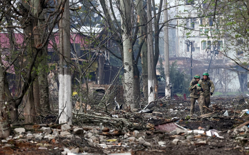 EDITORS NOTE: Graphic content / Ukrainian servicemen walk down a street in the frontline city of Bakhmut, Donetsk region on April 23, 2023, amid the Russian invasion of Ukraine. (Photo by Anatolii Stepanov / AFP)