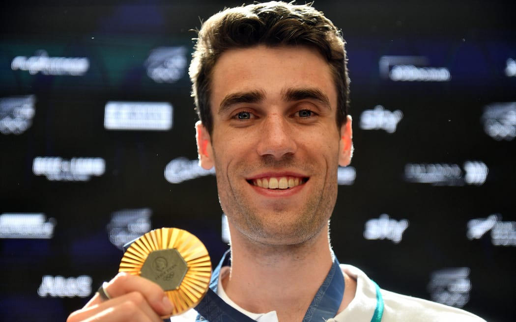 New Zealand high jumper Hamish Kerr shows off his Olympic gold medal