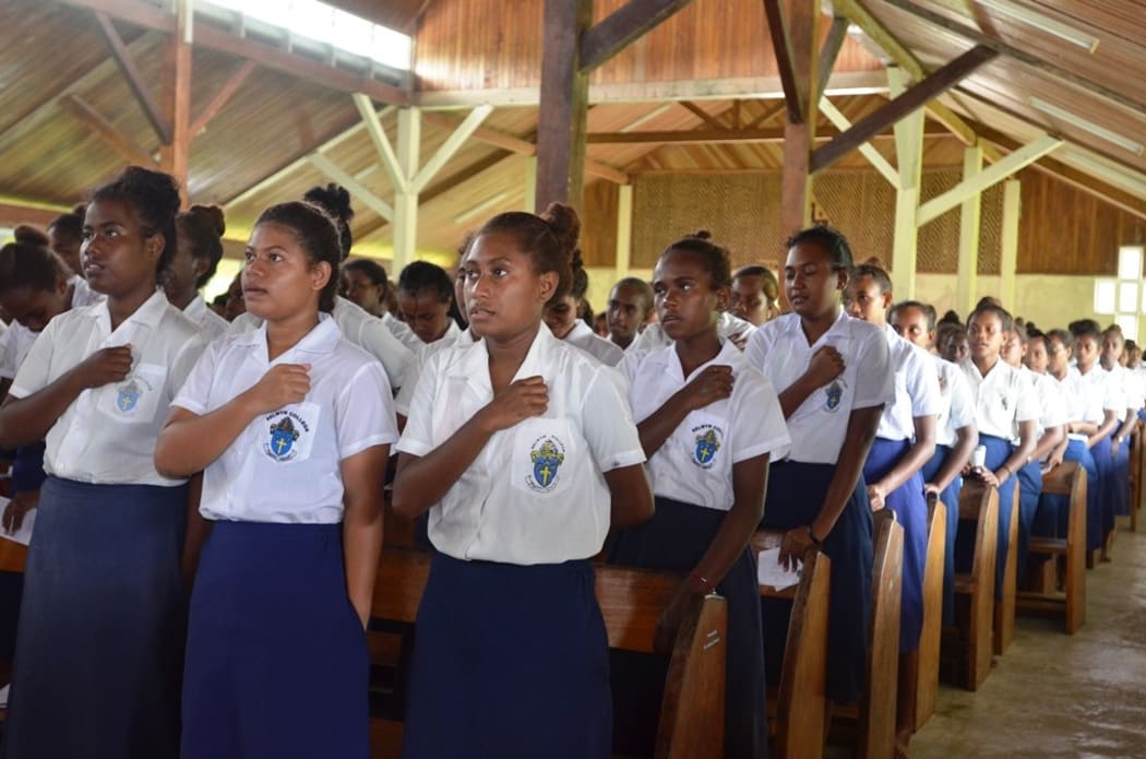 Students of Selwyn College sing the National Anthem.