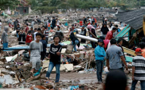 Rescuers and residents look for survivors along the coast in South Lampung on South Sumatra on 23 December, 2018, after the area was hit by a tsunami a day earlier.