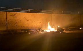 A picture published by the media office of the Iraqi military's joint operations forces on their official Facebook page shows a destroyed vehicle on fire following a US strike on January 3, 2020 on Baghdad international airport road.