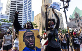 People raise their fists as they march during an event in remembrance of George Floyd in Minneapolis, Minnesota, on 23 May 2021.