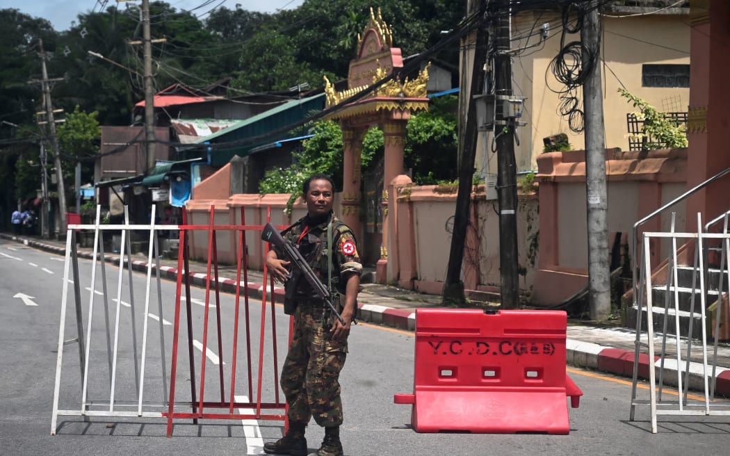 A member of the Myanmar security forces stands by a checkpoint in Yangon on July 19, 2022, on the 75th Martyrs' Day that marks the anniversary of the assassination of independence leaders including general Aung San, father of the currently deposed and imprisoned leader Aung San Suu Kyi. (Photo by AFP)