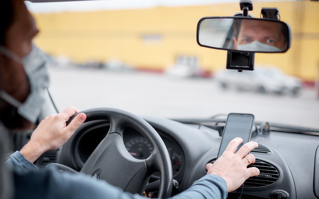 Taxi driver using phone for navigation.