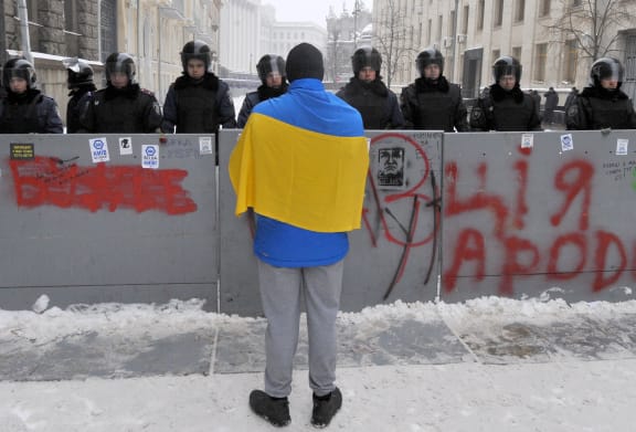 A protester confronts police guarding the office of President Viktor Yanukovych.